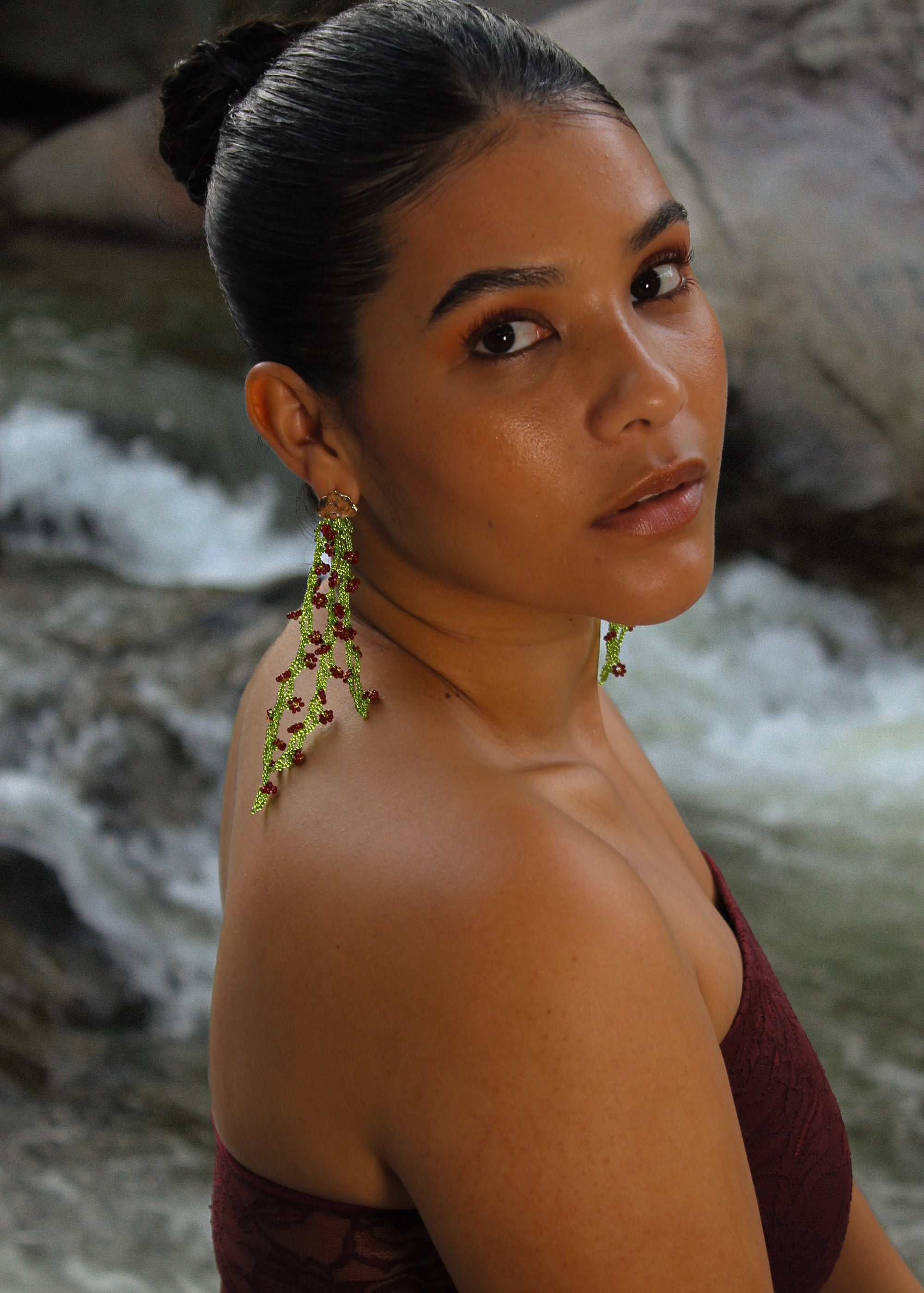 Woman with green earrings against a natural background